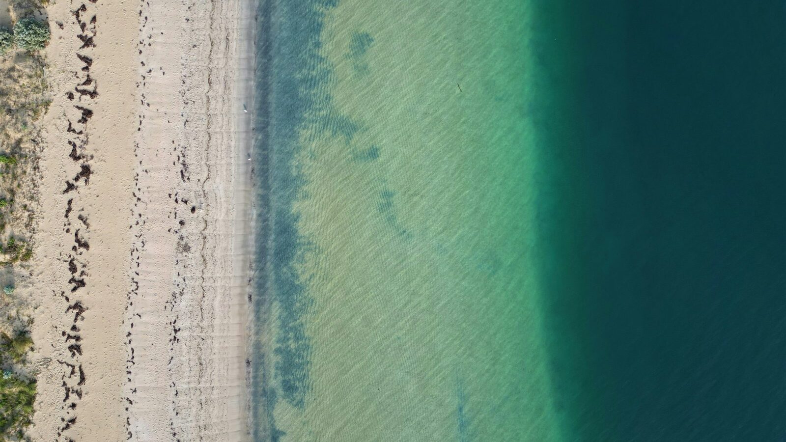 an aerial view of Rockingham beach with people walking on it