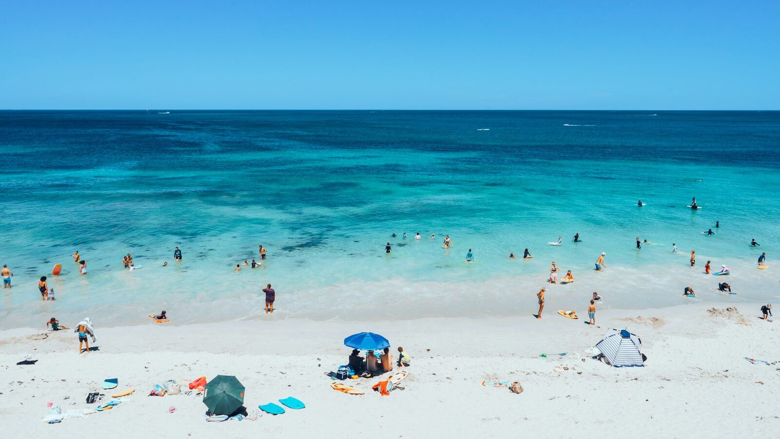 many people are on the beach and in the water